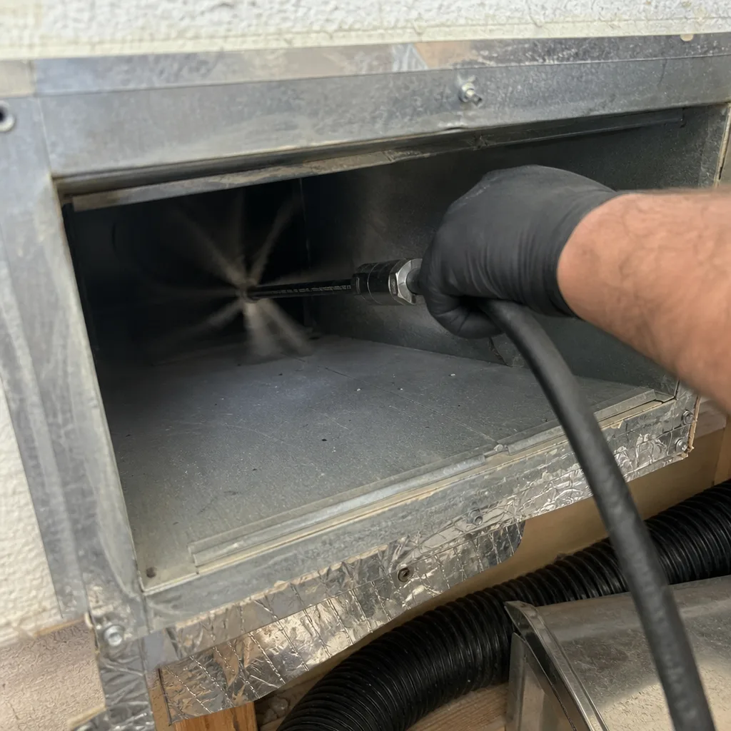 Technician using a rotating tool for professional air duct cleaning service
